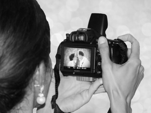 une femme regarde l'écran de son appareil photo lors d'un mariage