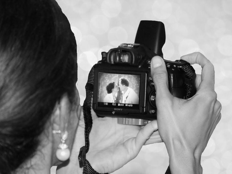 une femme regarde l'écran de son appareil photo lors d'un mariage