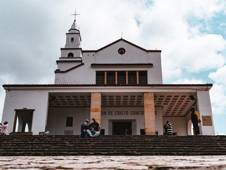 des gens assis sur les marches d'une église en Colombie
