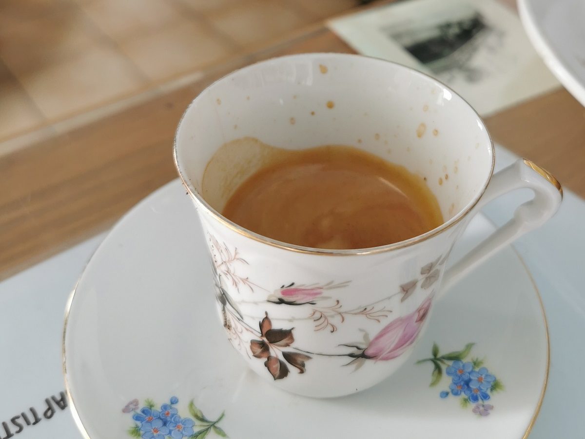 une tasse de café fleurie avec sa sous tasse et ses fleurs bleues