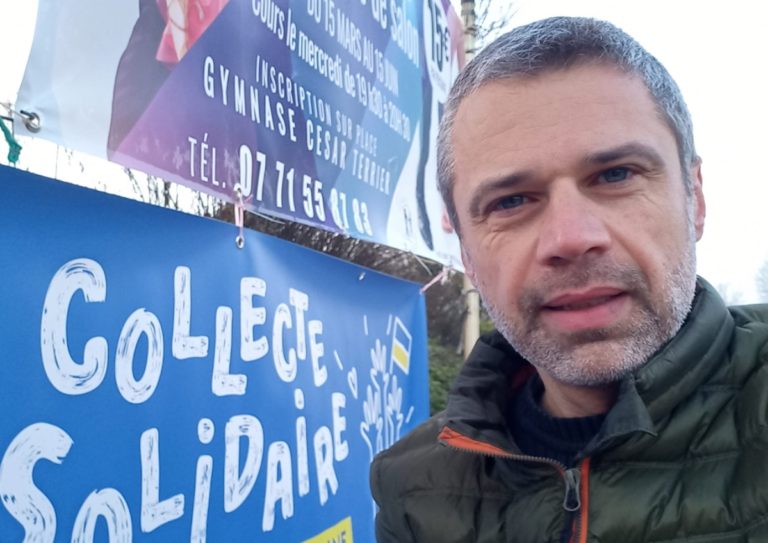 Michael Jacquet près d'une banderole pour une collecte solidaire