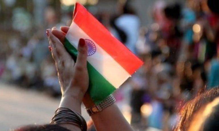Des mains en prière tiennent un drapeau indiens