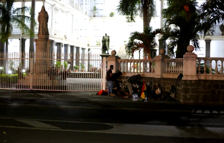 Plusieurs rastafaris posent leurs affaires devant l'hôtel du gouvernement à Port-Louis.