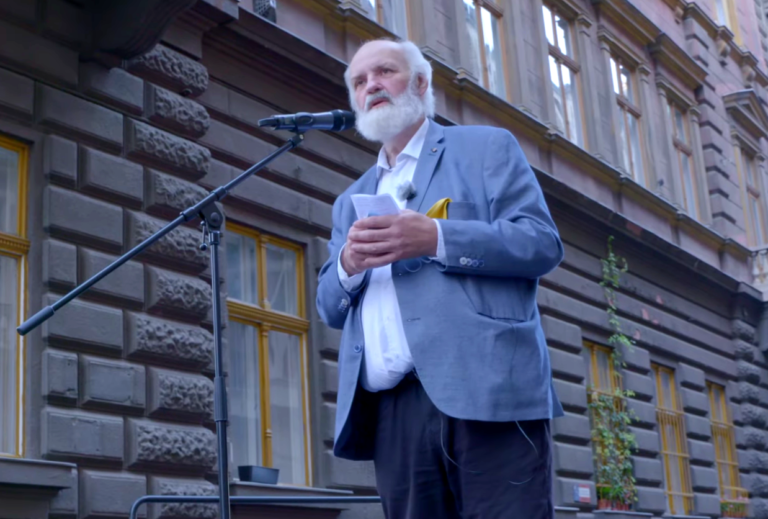 Gábor Iványi fait un discours sur une estrade dans la rue