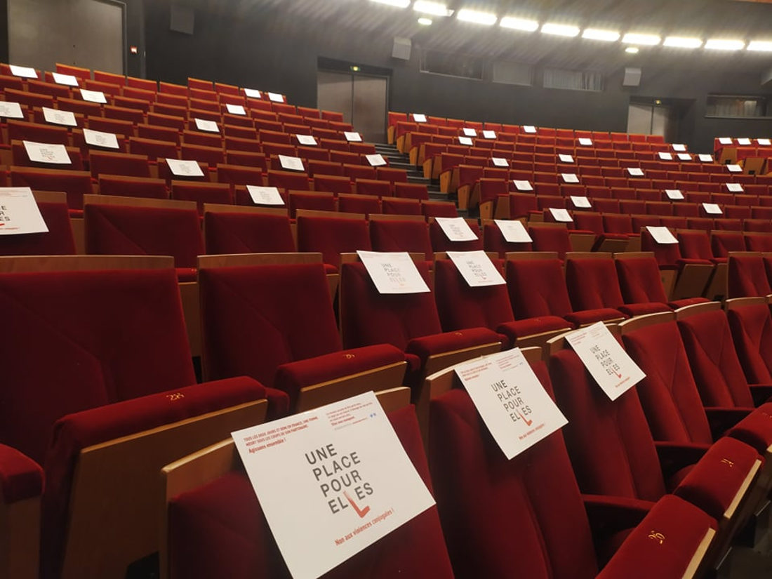 De petites pancartes sur les chaises d'un cinéma vide.