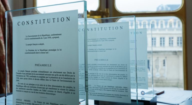 présentation de pages de la Constitution française sous verre