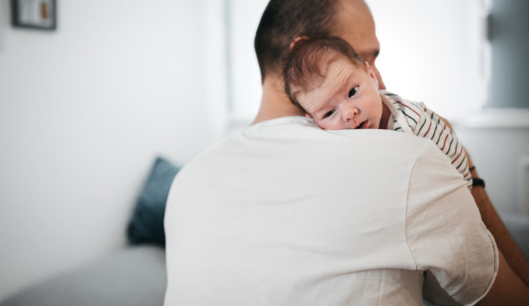 Un homme serre son bébé contre lui