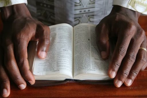 Deux mains posées sur une Bible ouverte