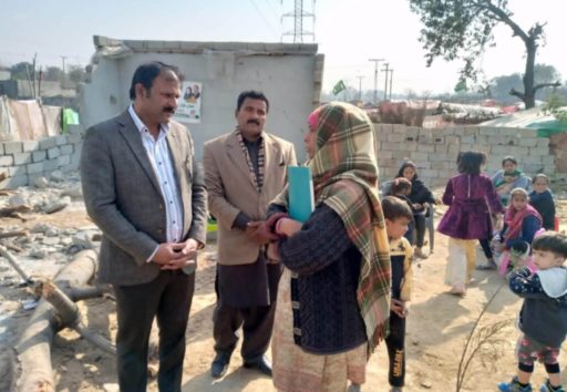 Au milieu des ruines, une pakistanaise explique à deux hommes la situation de sa communauté