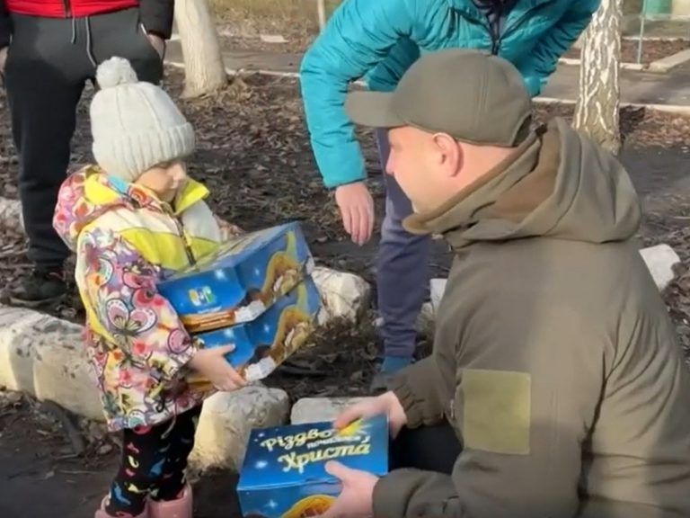 Le pasteur ukrainien Igor Kamenev distribue des cadeaux à un enfant du Donbass