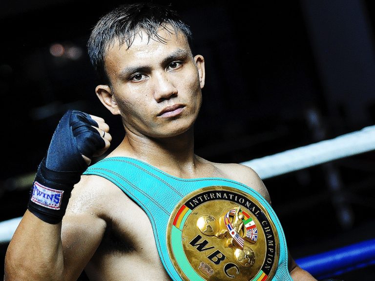 un boxeur poing levé avec la ceinture de champion du monde autour du corps