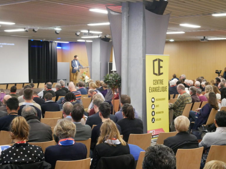 Des chrétiens sont assis dans une grande salle lors du Centre évangélique 2021 et écoutent un orateur