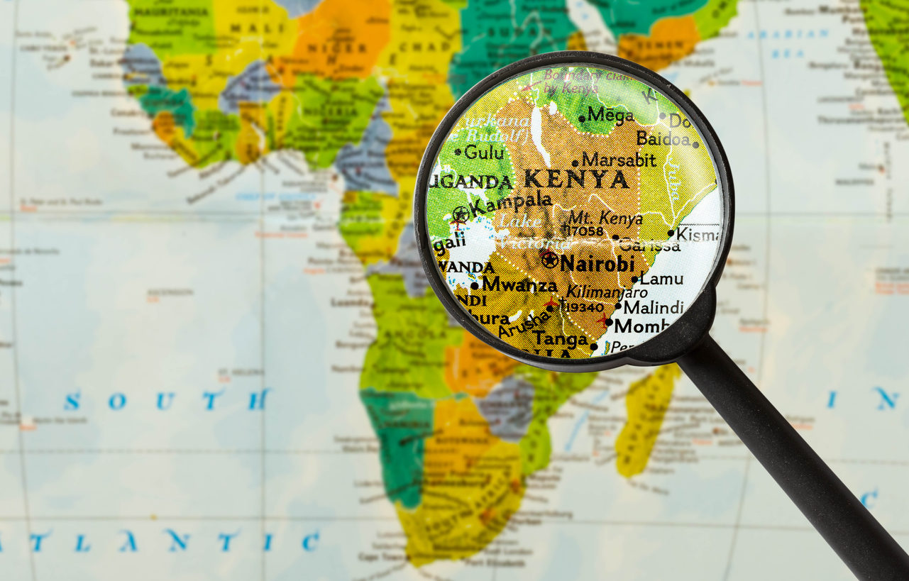 Une loupe est posée au dessus du Kenya sur une carte de l'Afrique