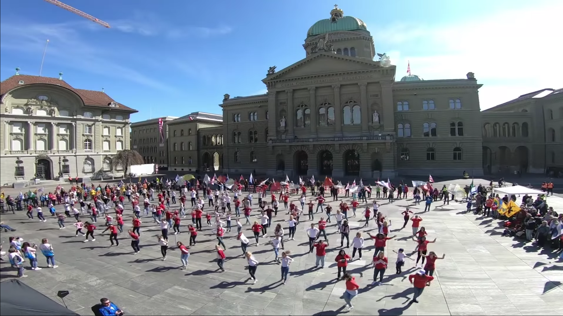 Des dizaines de personnes dancent en même teps sur la Place fédérale de Berne