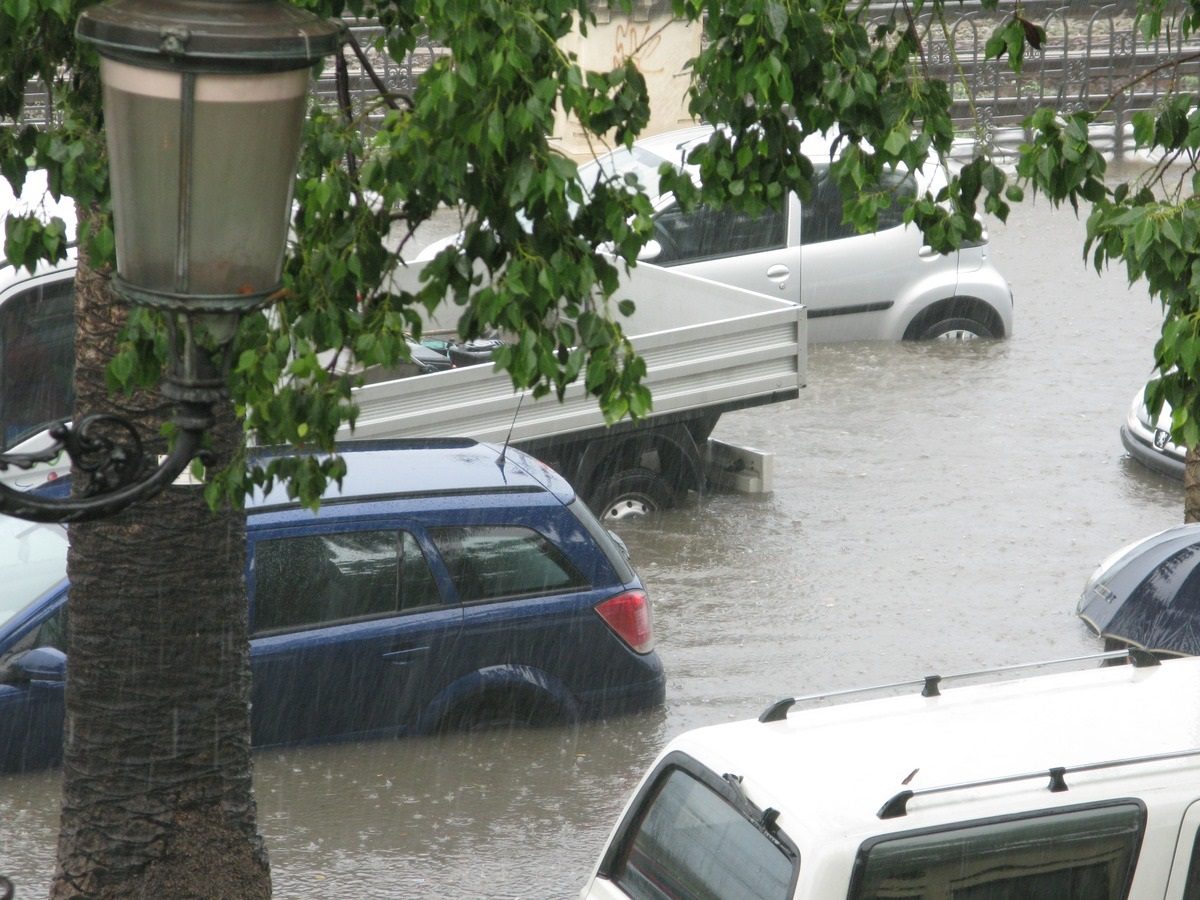 Dans une rue, des voitures sont submergées d'eau