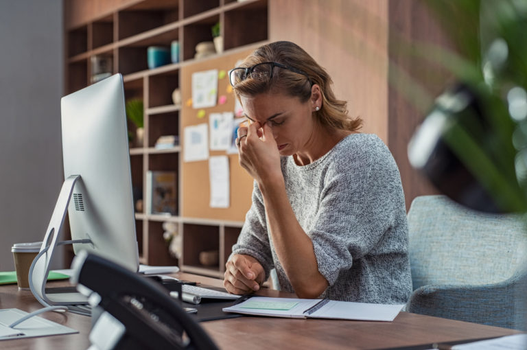 Une femme montre s signes de fatigue devant son ordinateur