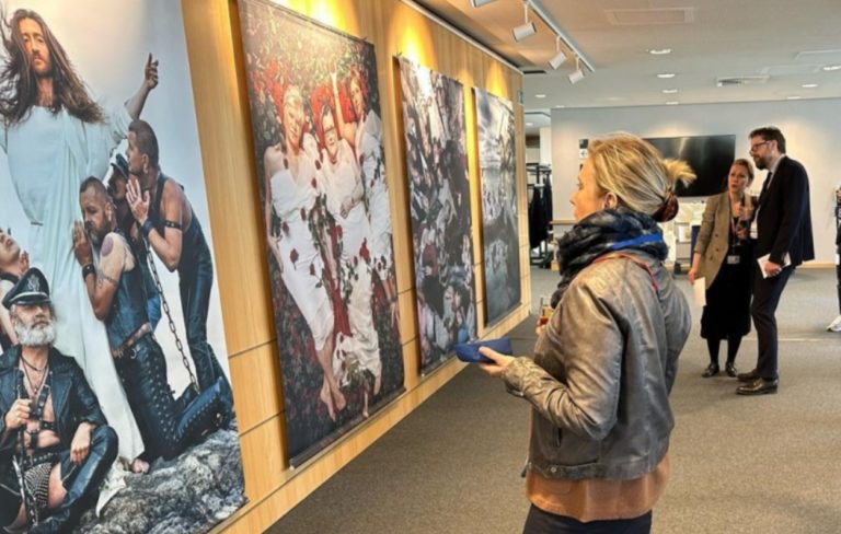 Plusieurs personnes regardent les affichent dans un couloir du Parlement européen