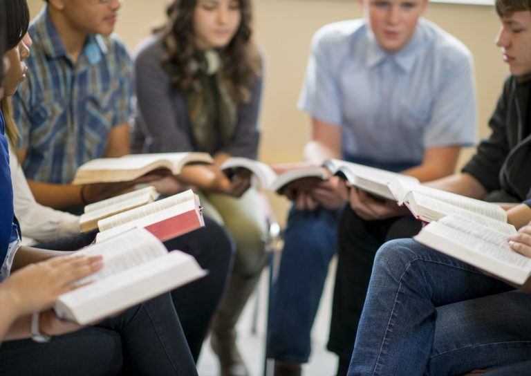 Un groupe d'adolescents lit la Bible