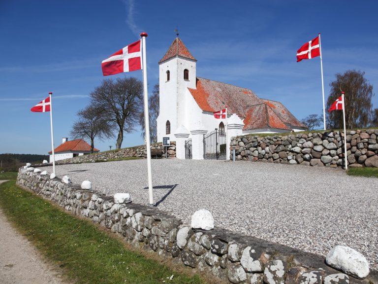 Une route avec des drapeaux du Danemark mène à une Eglise