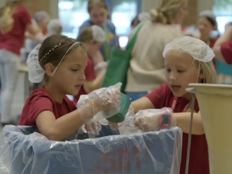 Deux filles préparent des colis alimentaires munis de gants pour l'hygiène