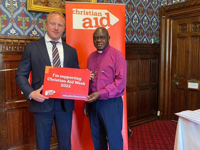 L'homme politique Sam Tarry et John Sentamu, président de l'ONG Christian Aid, tiennent une pancarte: "Je soutiens la semaine Christian Aid 2022"