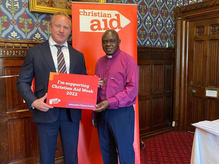 L'homme politique Sam Tarry et John Sentamu, président de l'ONG Christian Aid, tiennent une pancarte: "Je soutiens la semaine Christian Aid 2022"