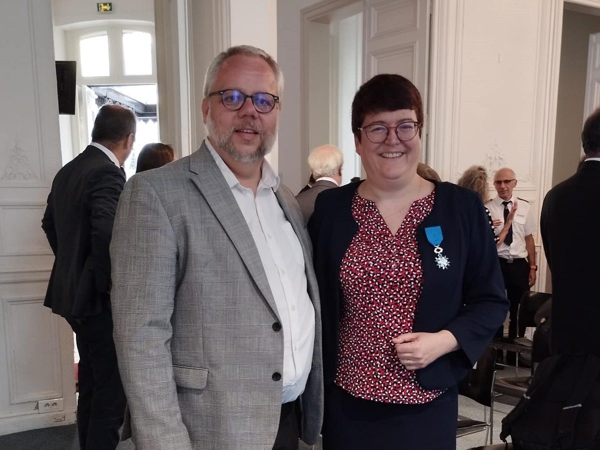 Valérie Duval-Poujol portant sa médaille de chevalier de l'ordre national du mérite aux côtés du pasteur Vincent Miéville