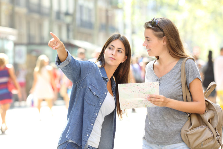 Une femme montre quelque chose du doigt à une autre, dans la rue