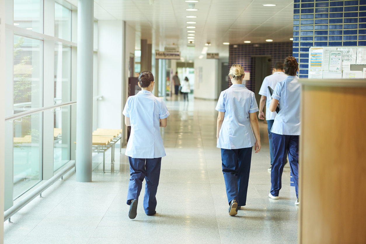 Trois infirmières marchent dans un couloir d'hôpital