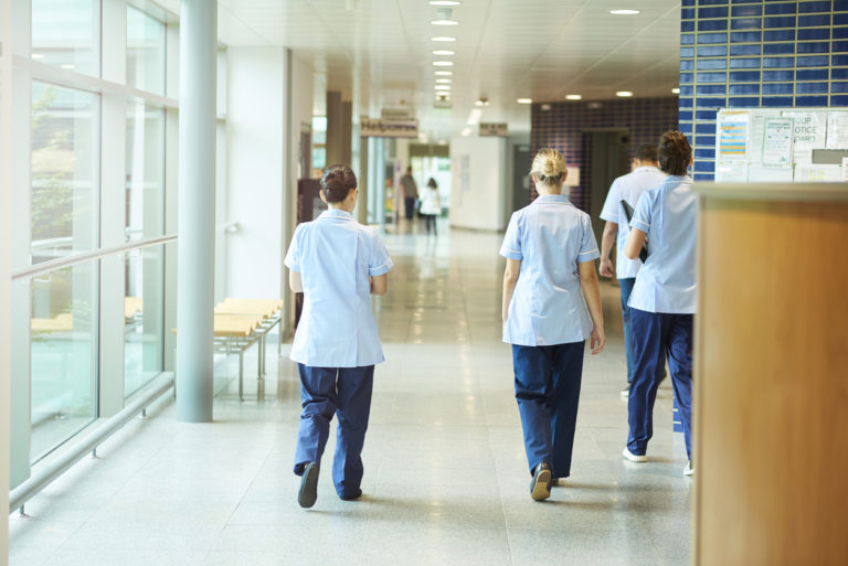 Trois infirmières marchent dans un couloir d'hôpital