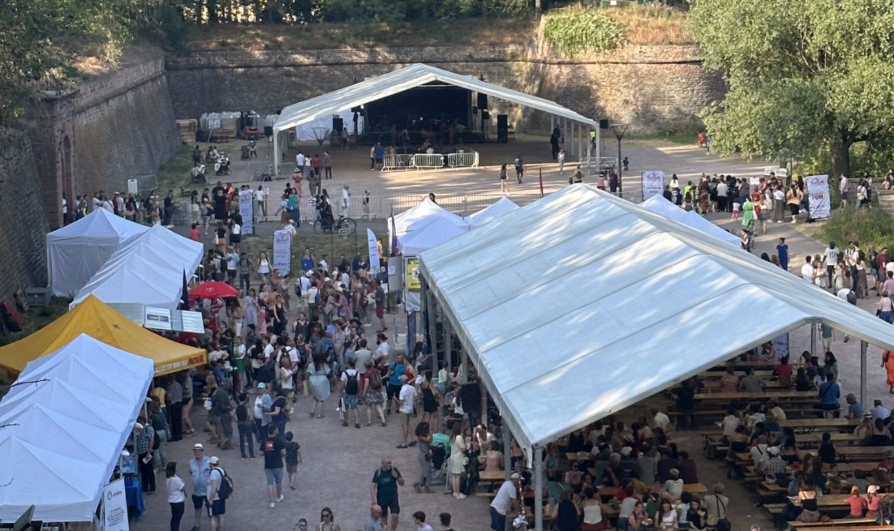 Une foule de personnes marche entre les stands en plein air