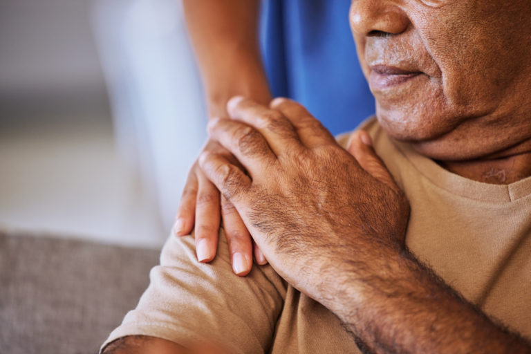 Une patiente pose sa main sur celle d'une infirmière, sur son épaule.