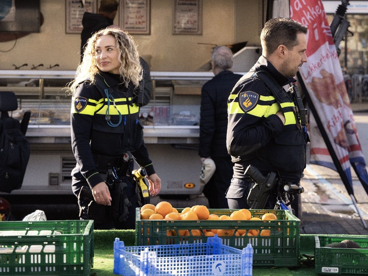 Deux policiers, une femme et un homme, arpentent un marché aux Pays-Bas