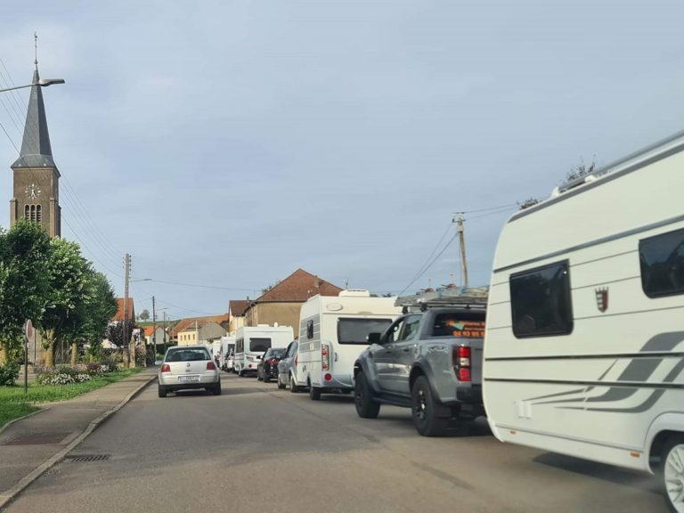 Des voitures et leurs caravanes dans le village de Grostenquin