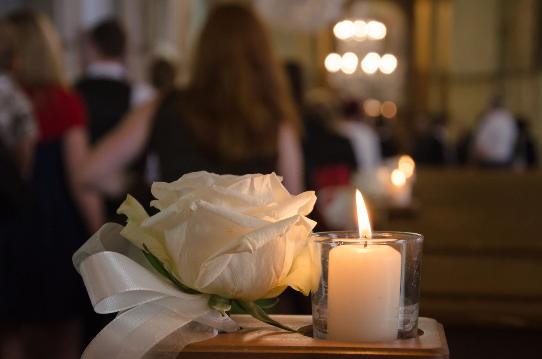 Une rose et une bougie sont posées à l'entrée d'une église