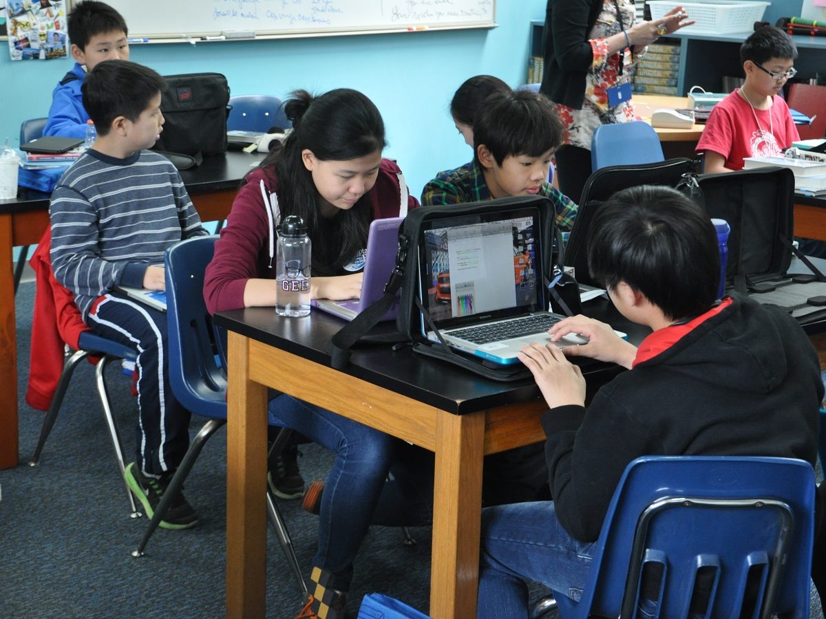 Des enfants chinois travaillent sur des bureaux à l'école