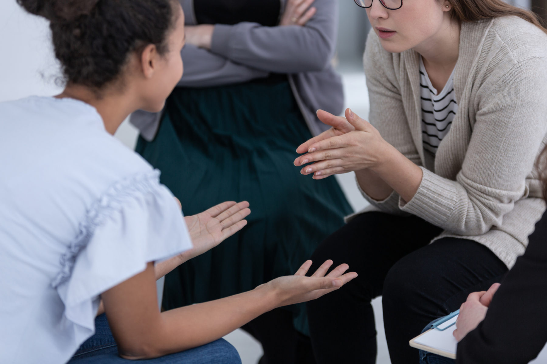 Parmi un groupe de parole, une jeune femme essaie d'expliquer quelque chose à une autre