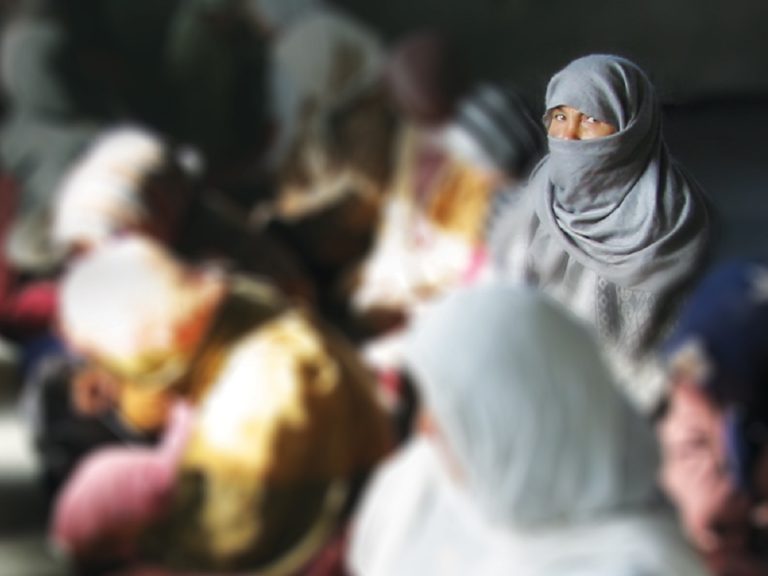 Zoom sur un groupe de femmes afghanes voilées, toutes sont floutées sauf une
