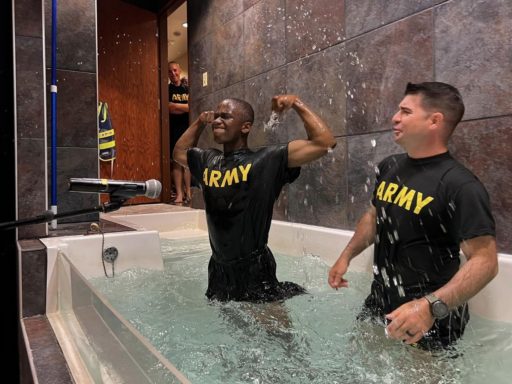Un jeune militaire noir-américain exprime sa joie après avoir été baptisé par un aumônier aux armées