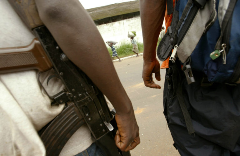 Deux hommes armés marchent dans la rue