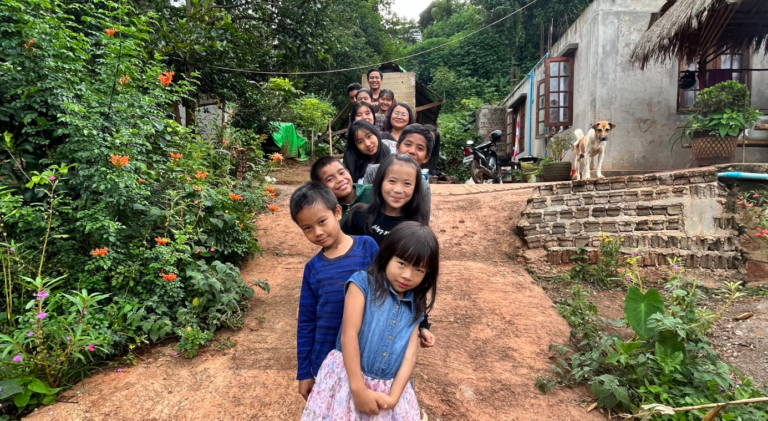 Des enfants au Myanmar posent à la queue-le-leu en regardant vers le lecteur.