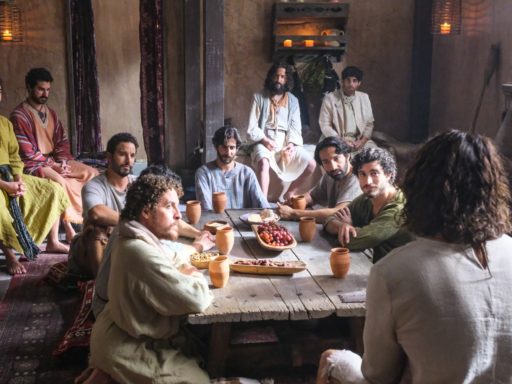 De dos, Jésus (joué par Jonathan Roumie dans la série The Chosen) s'adresse aux disciples, assis autour d'une table