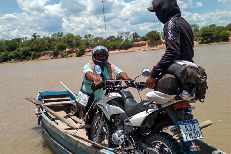 Un missionnaire charge une moto sur une barque