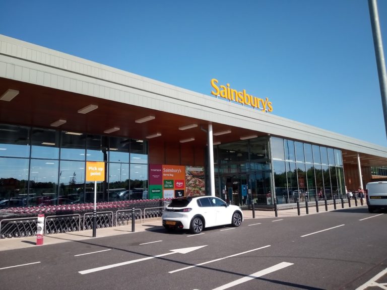 Une voiture stationnée devant un supermarché Sainsbury's