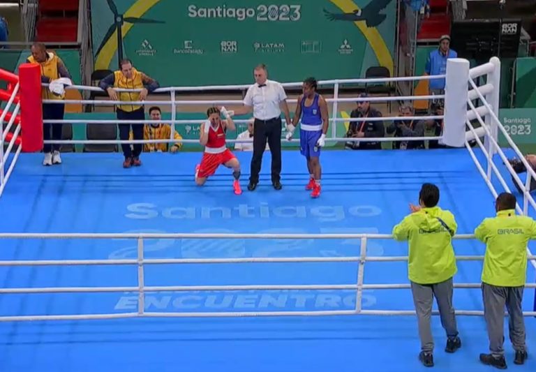 Yeni Arias s'agenouille sur le ring après sa victoire lors de la finale des Jeux panaméricains, l'arbitre vient de lever son bras