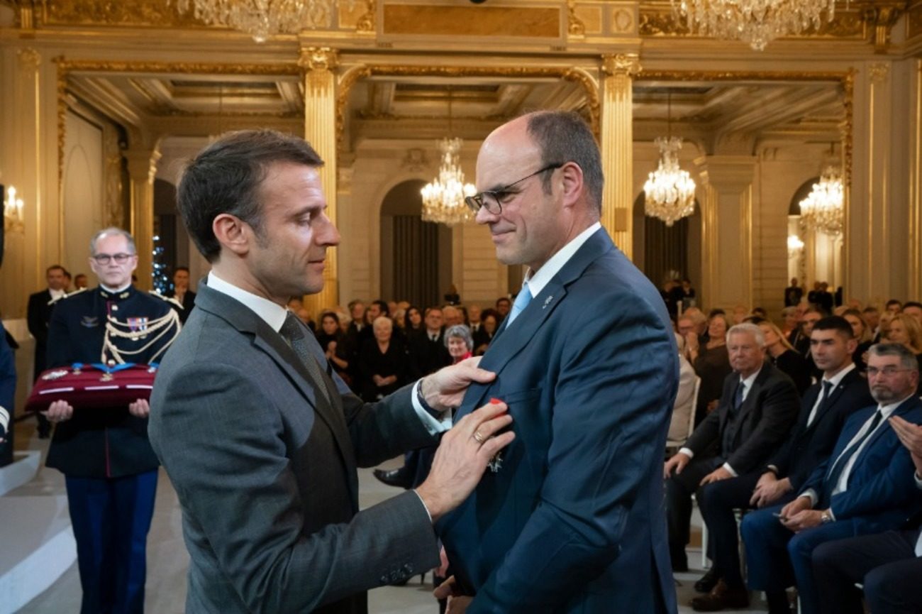Le président français Emmanuel Macron attache l'insigne de la Légion d'honneur sur la poitrine de Christian Krieger