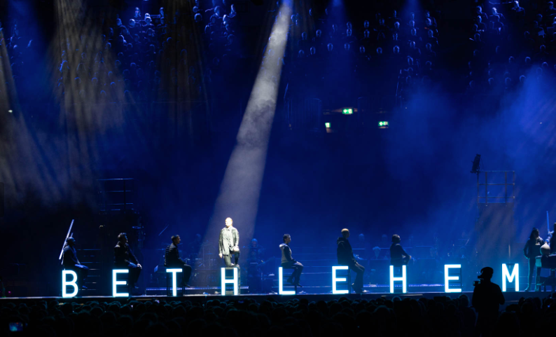 Une scène avec les lettre bethlehem illuminées, un projecteur éclair une personne
