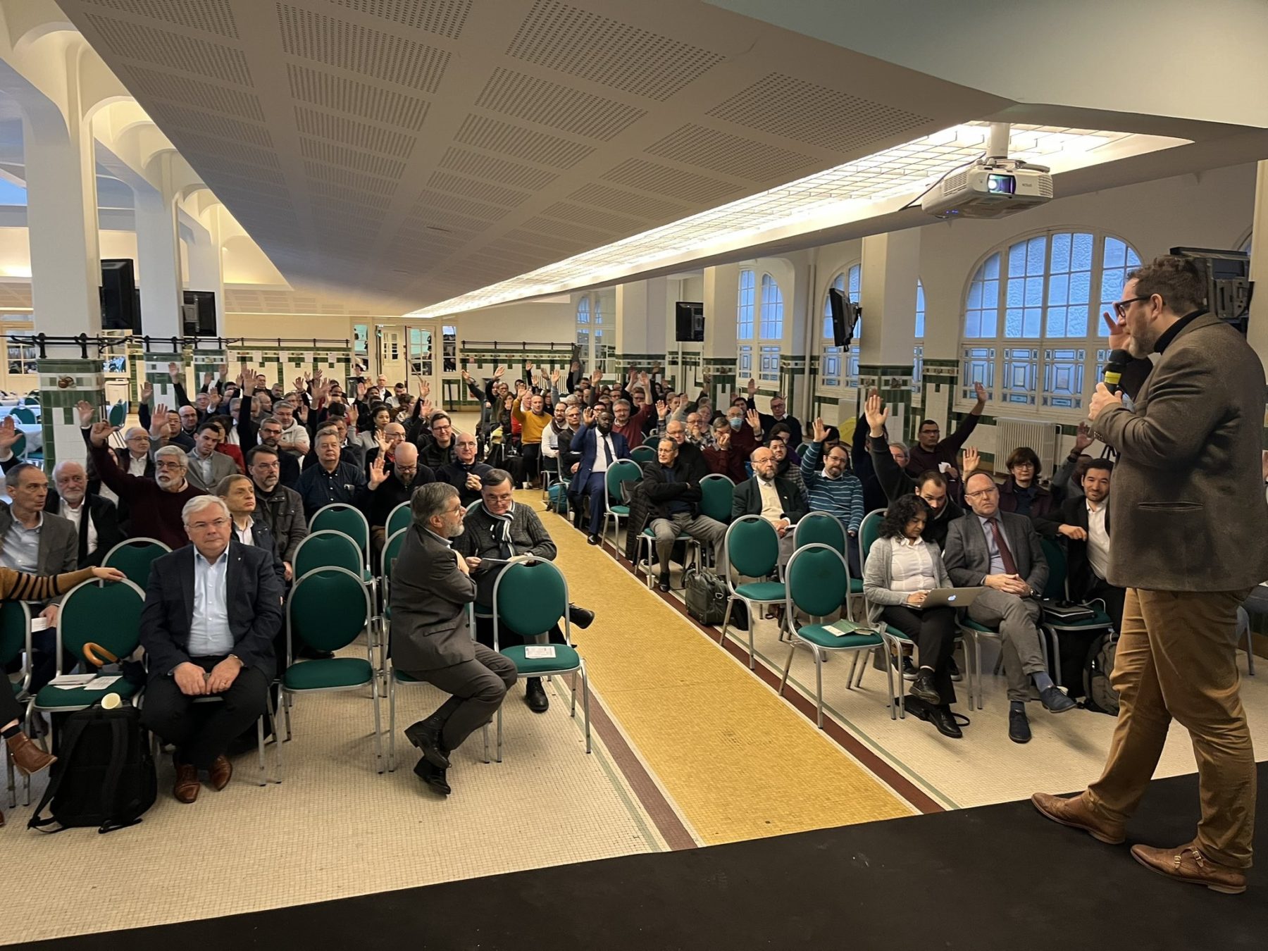 Les membres du CNEF lèvent le bras pour voter, Erwan Cloarec, son président, est debout sur scène avec le micro