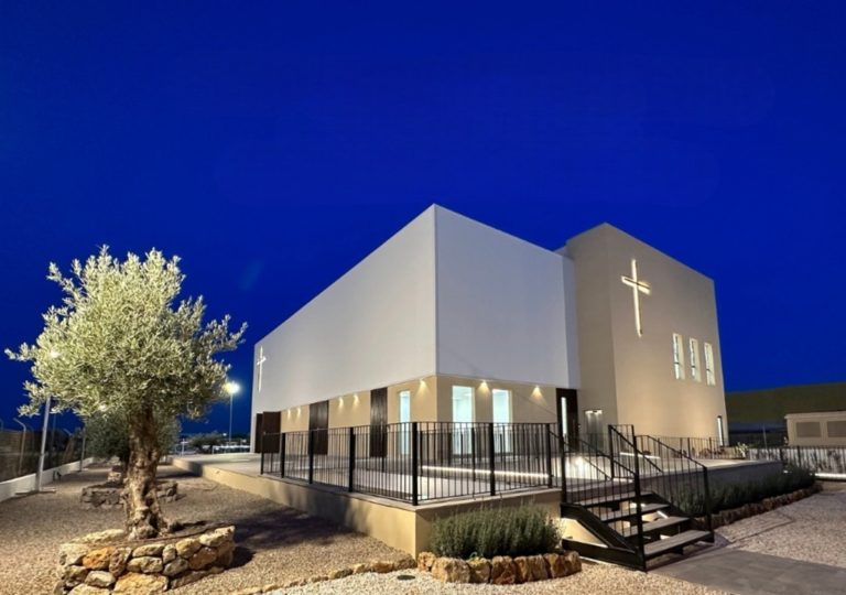 Image de nuit du bâtiment de l'Eglise évangélique de Palma de Majorque avec un olivier à l'extérieur
