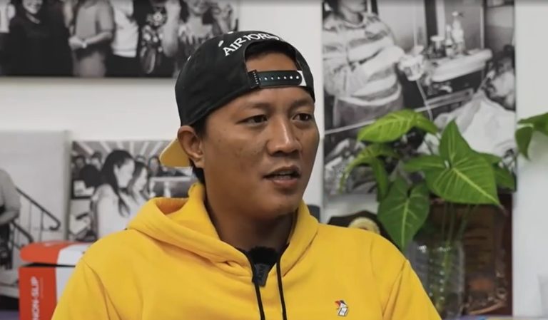 Jimmy Pacheko avec un sweat jaune et une casquette s'exprime devant la caméra de CBN